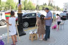 На тротуаре одной из бакинских улиц появился вернисаж (ФОТО)