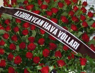 Люди приносят цветы к дому, где жил капитан разбившегося самолета AZAL  Игорь Кшнякин (ФОТО)