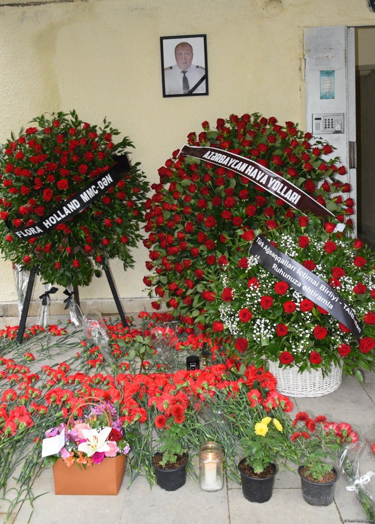 Люди приносят цветы к дому, где жил капитан разбившегося самолета AZAL  Игорь Кшнякин (ФОТО)