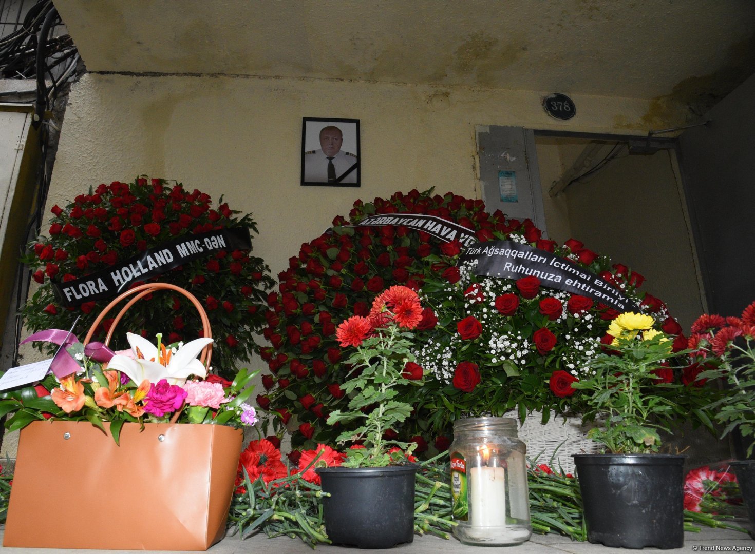 Люди приносят цветы к дому, где жил капитан разбившегося самолета AZAL  Игорь Кшнякин (ФОТО)